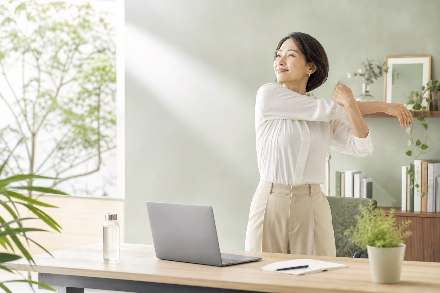 明るいワークスペースで立ち上がり肩を伸ばす40代の女性